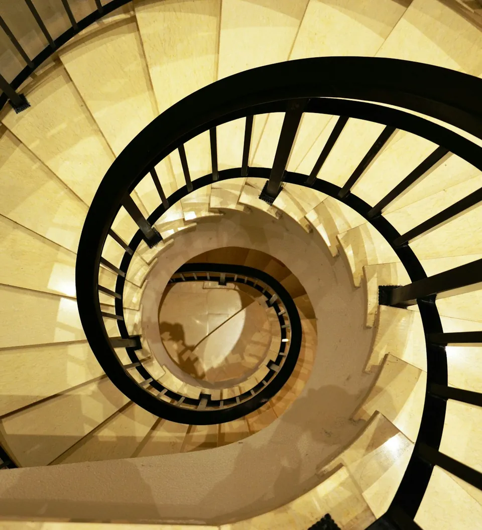 Escalera de caracol con baranda negra vista desde arriba
